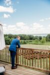 Once Finger Lakes groom on deck looking at lawn ceremony setup overlooking Seneca Lake